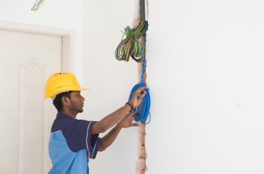 young-man-tying-cable-against-wall-large Wiring a house